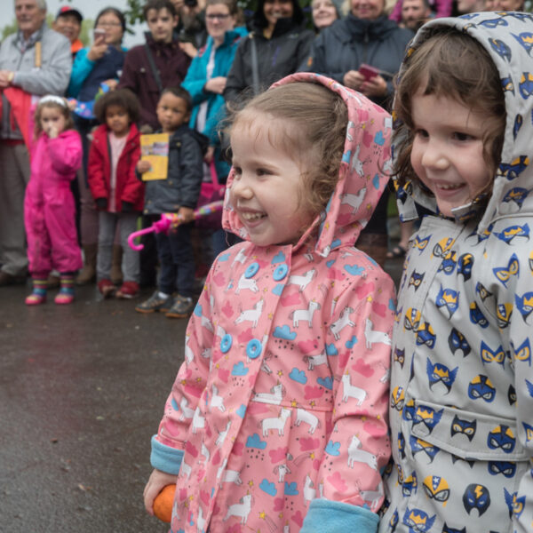 Two children outside in raincoats.