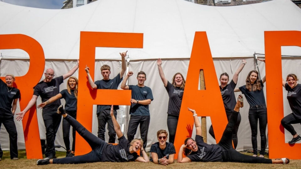 A group of volunteers stood outside the marquee tents holding the giant letters R E A D.