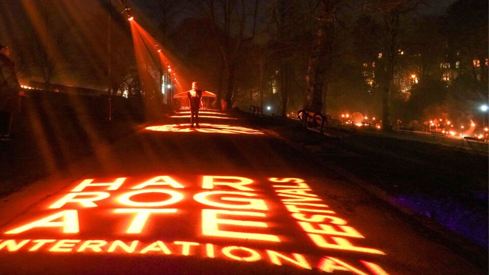 Harrogate International Festivals Logo projected onto the ground outside the venue.