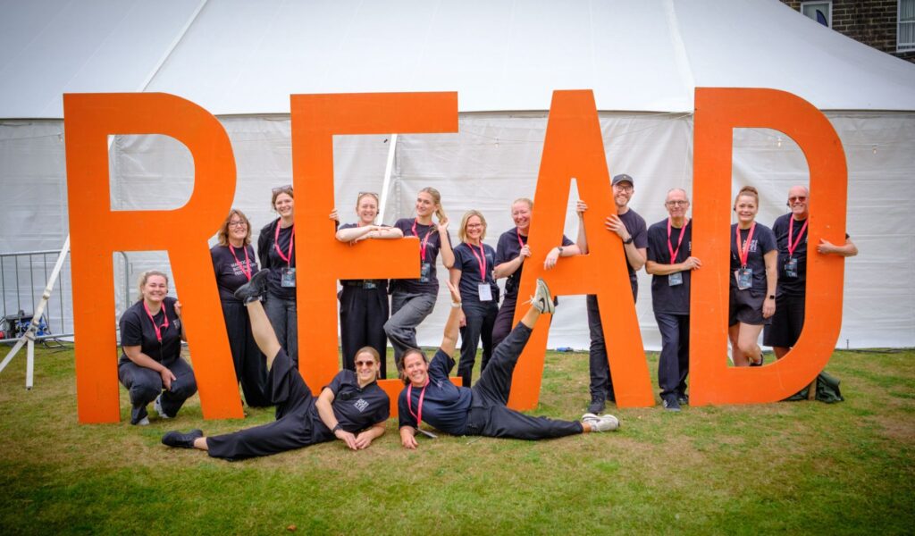 The Harrogate International Festival team posed smiling in front of the READ sign at the crime writing festival.